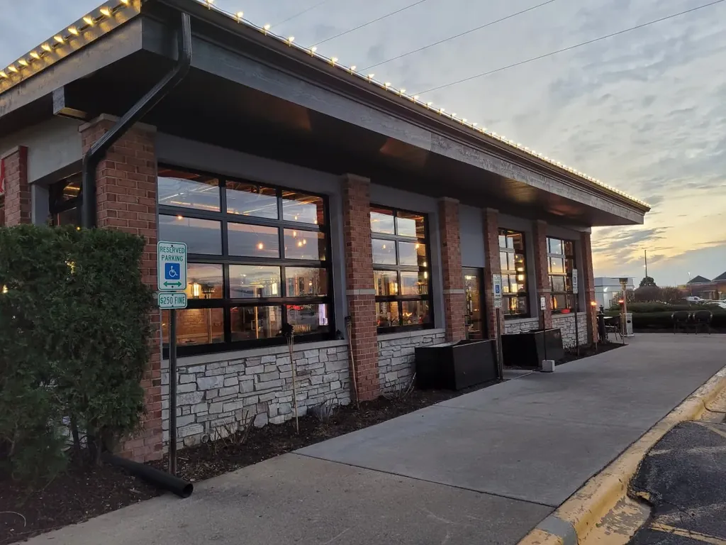 Restaurant and bar exterior with brick and stone facade at dusk