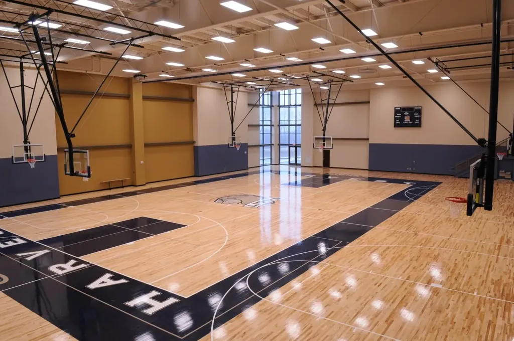 Gymnasium with hardwood basketball court and scoreboard