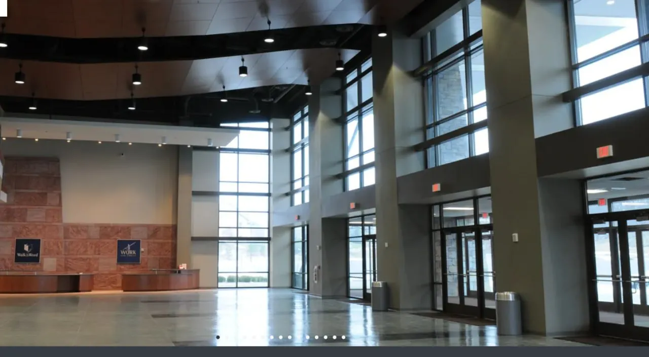 Modern institutional entrance hall with stone walls and glass doors